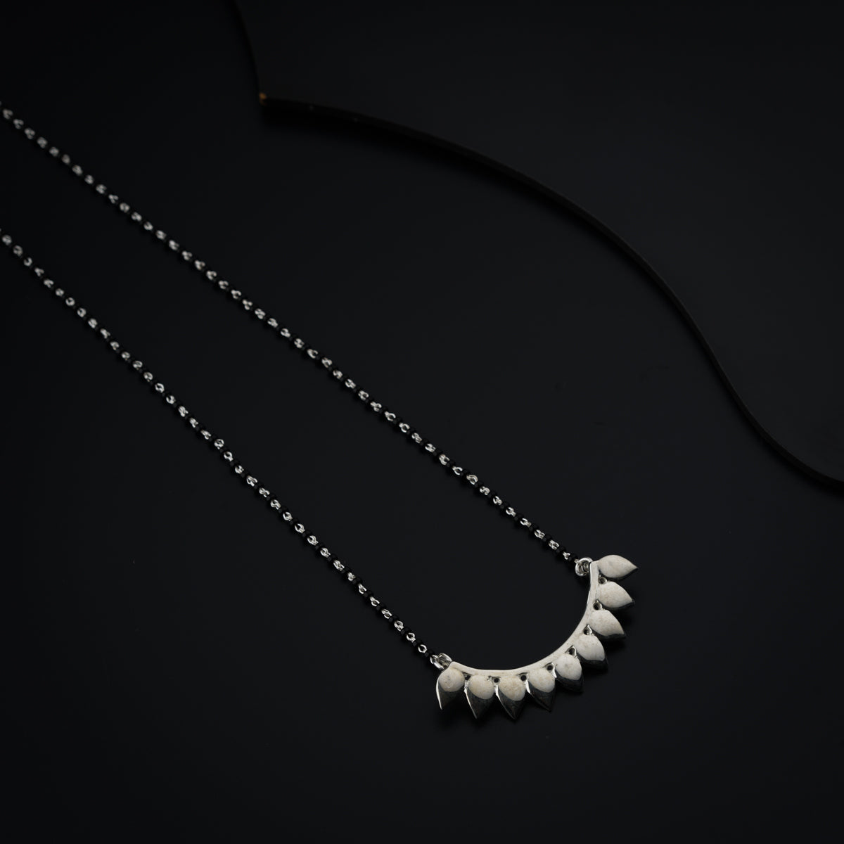 a necklace with five small white hearts hanging from it