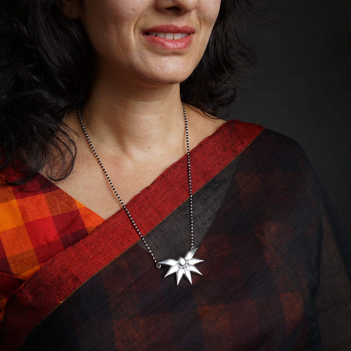 a woman wearing a necklace with a star on it