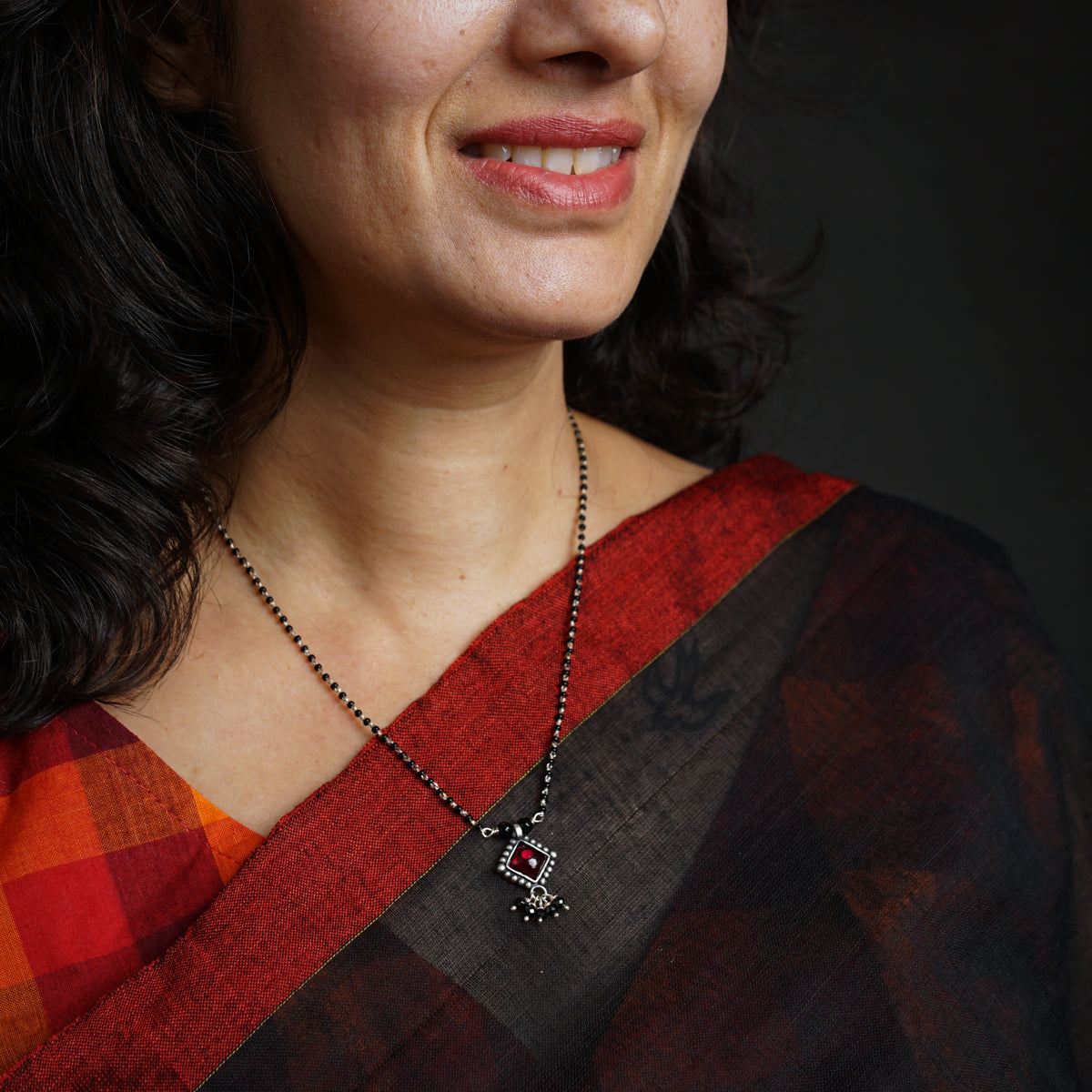 a woman wearing a necklace with a cross on it