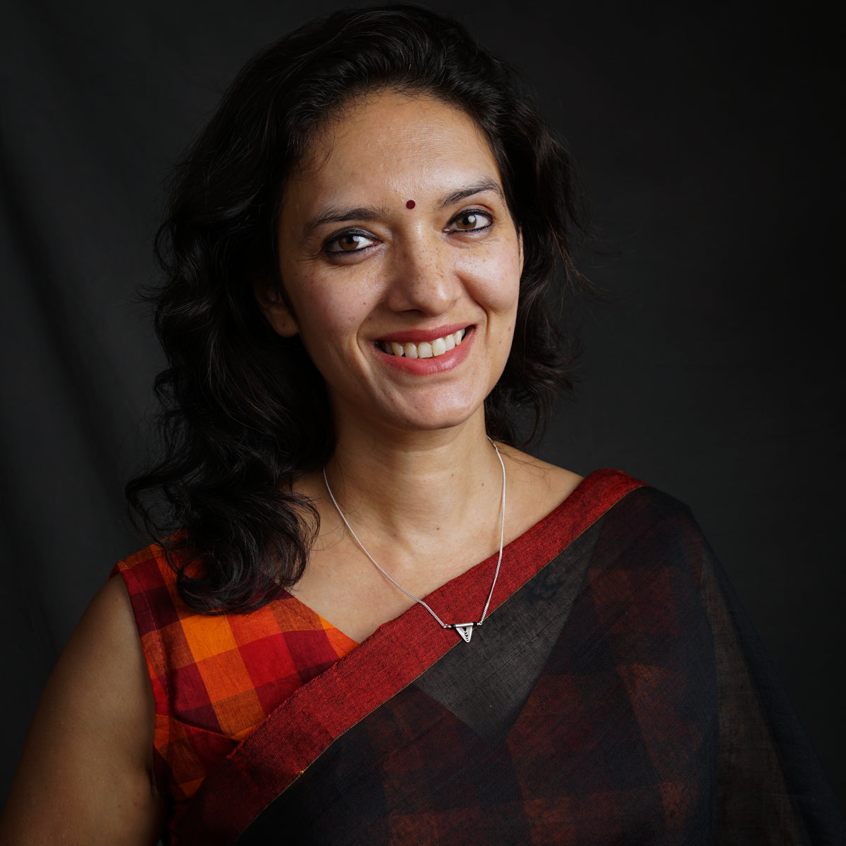 a woman wearing a red and black sari