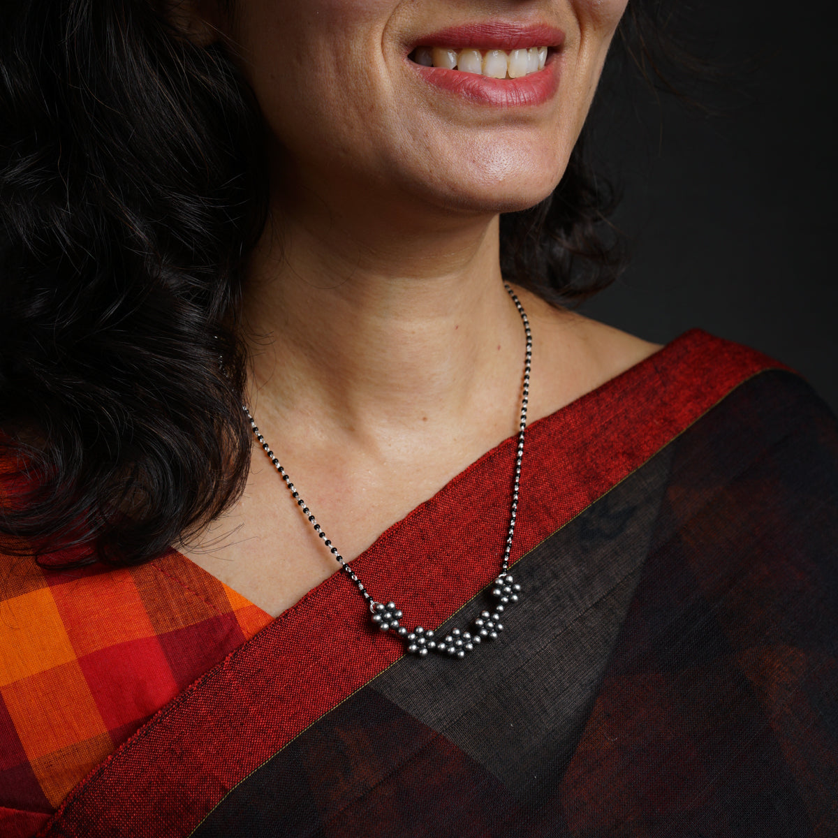 a woman wearing a red and black sari