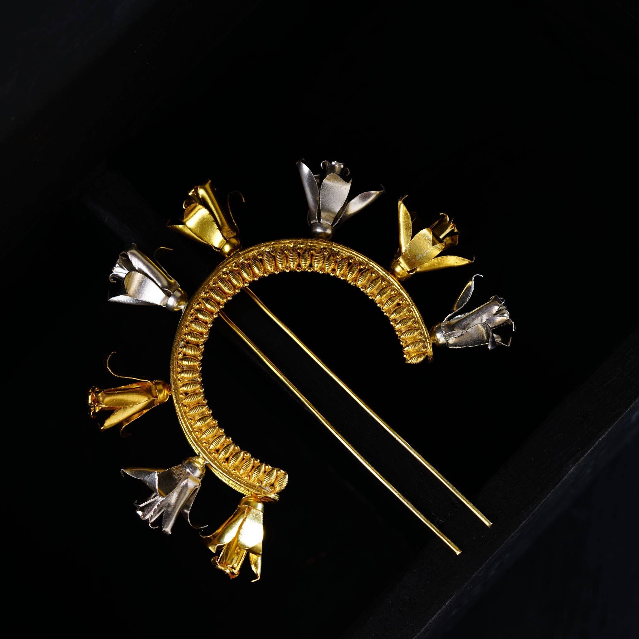 a gold brooch with spikes on it