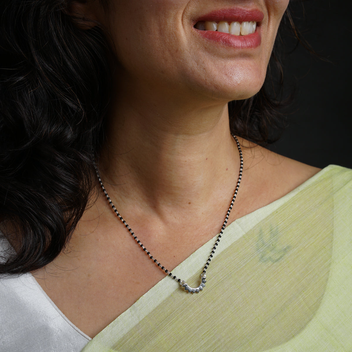 a close up of a woman wearing a necklace