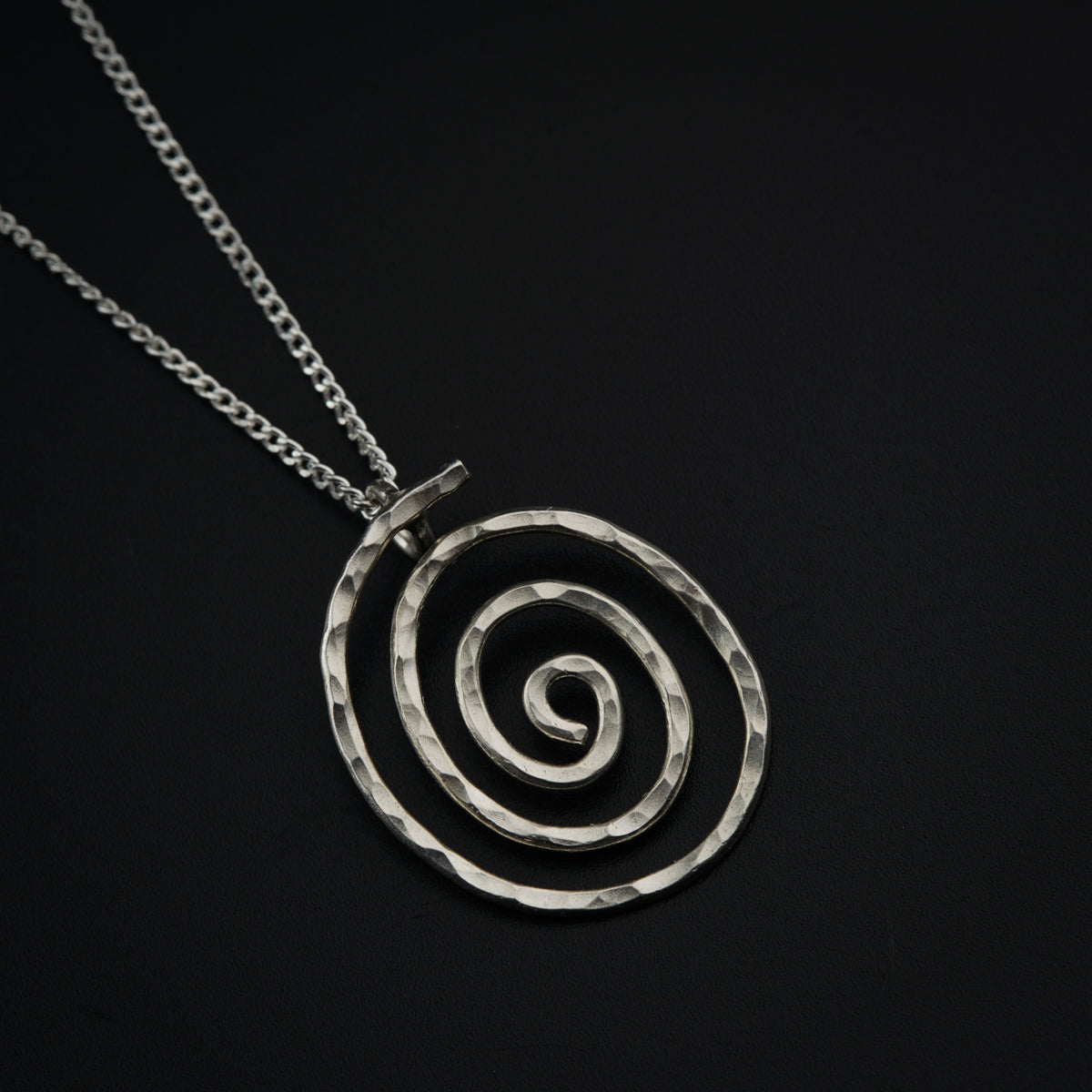 a silver necklace with a spiral design on it