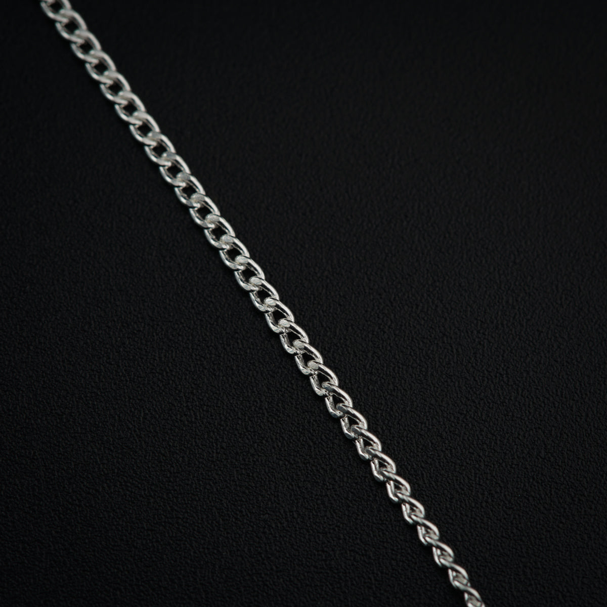 a close up of a chain on a black surface
