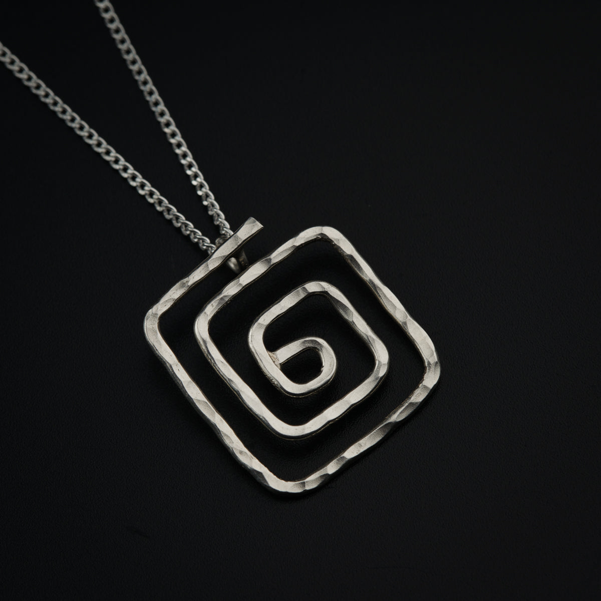 a square pendant with a letter on a chain