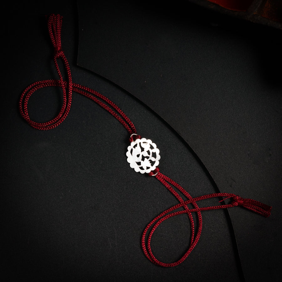 a red string with a white flower on it