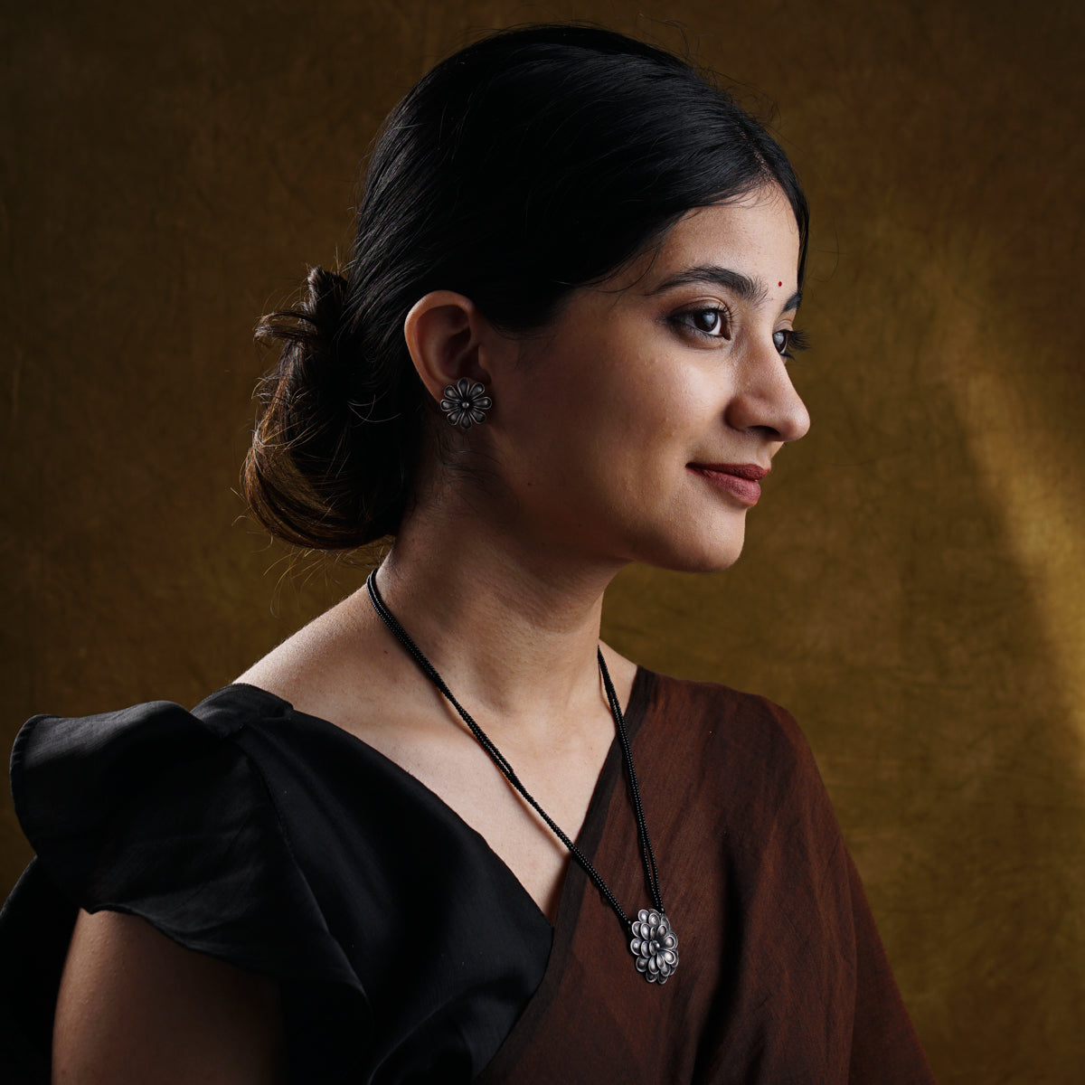 a woman wearing a necklace and a black dress