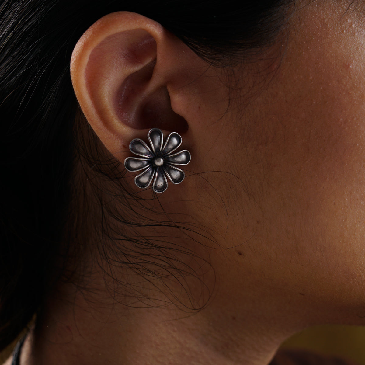 a close up of a person wearing a pair of earrings