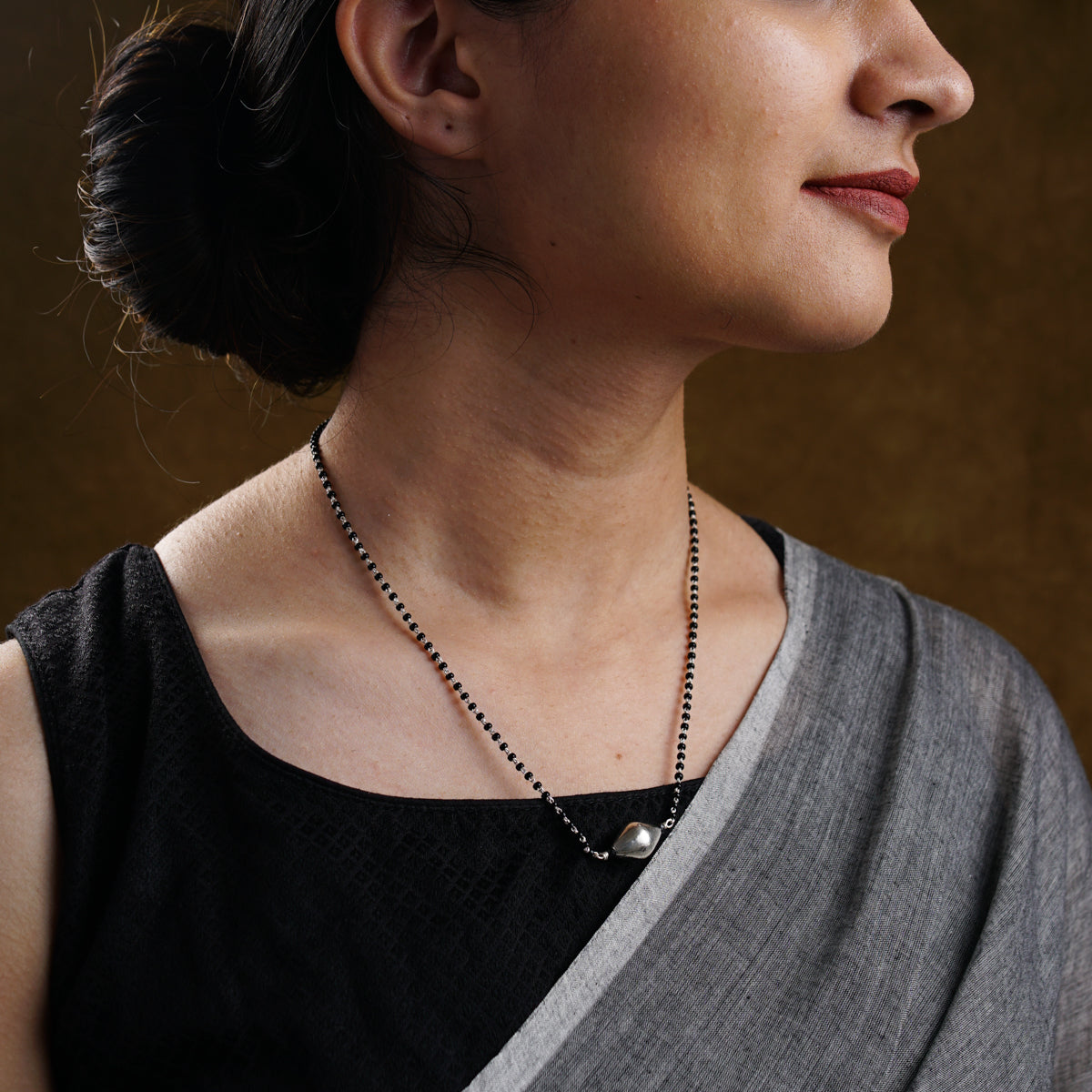 a woman wearing a black and silver necklace