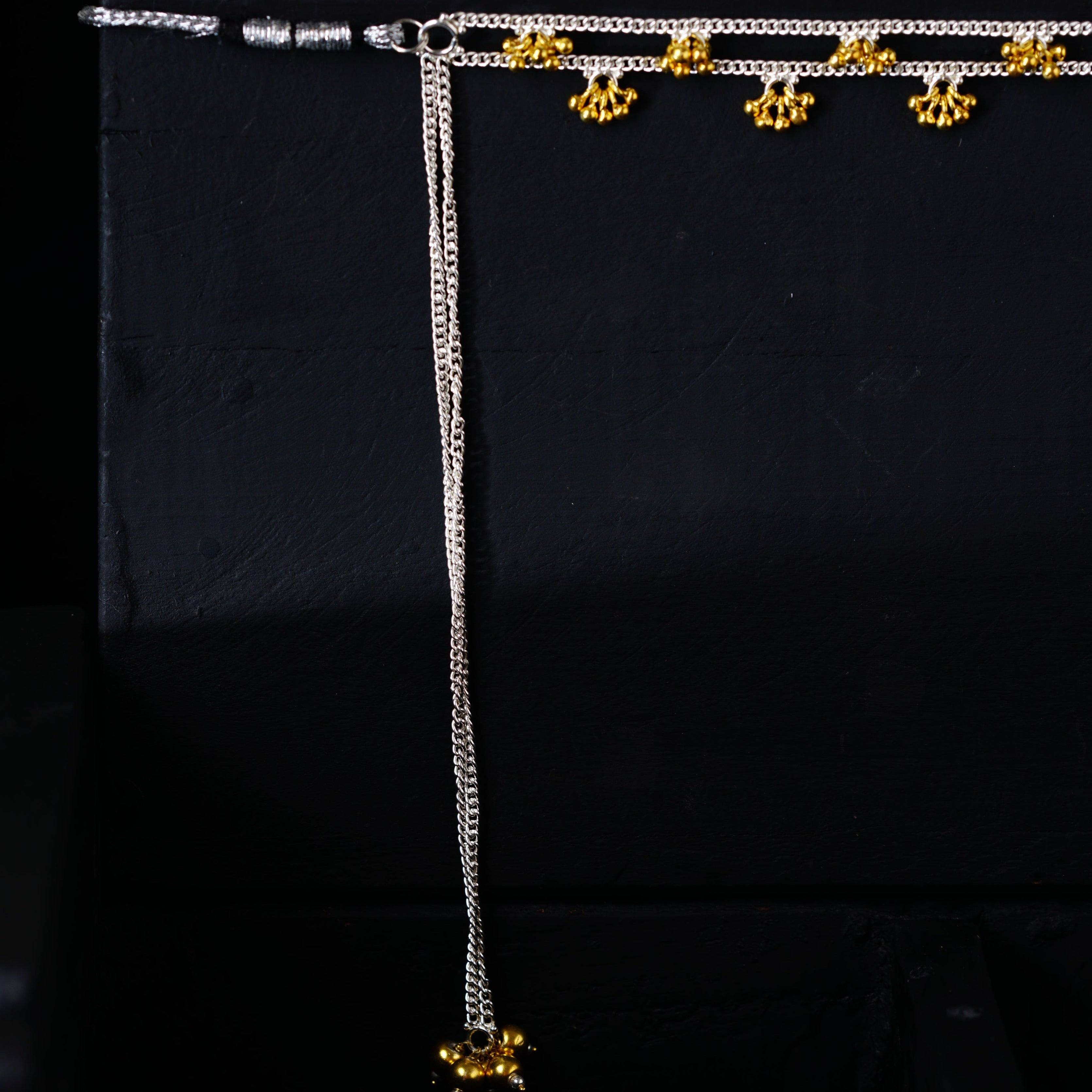 a black background with a white and gold necklace