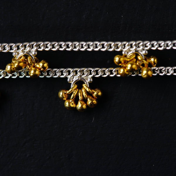 a close up of a metal chain with bells on it
