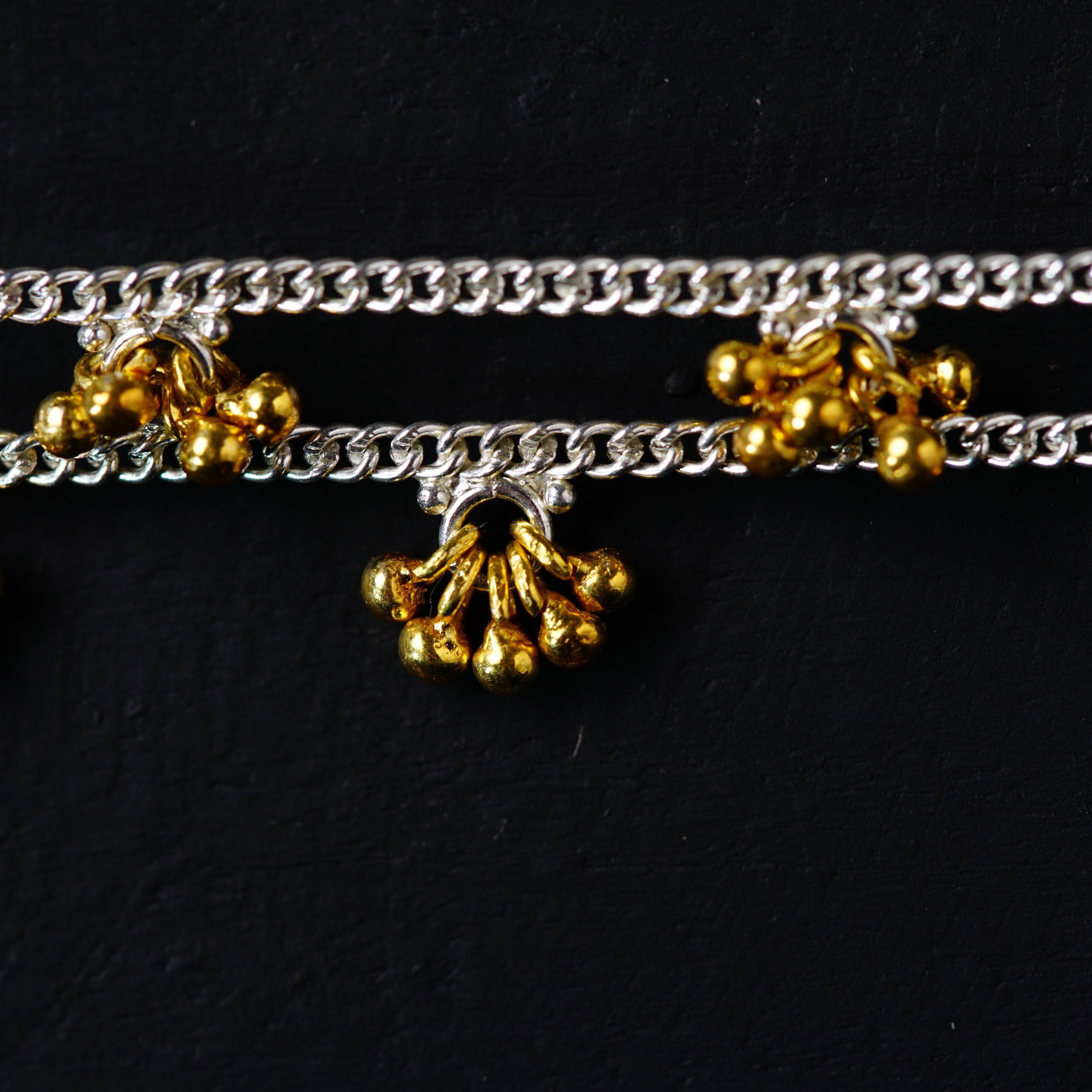 a close up of a metal chain with bells on it