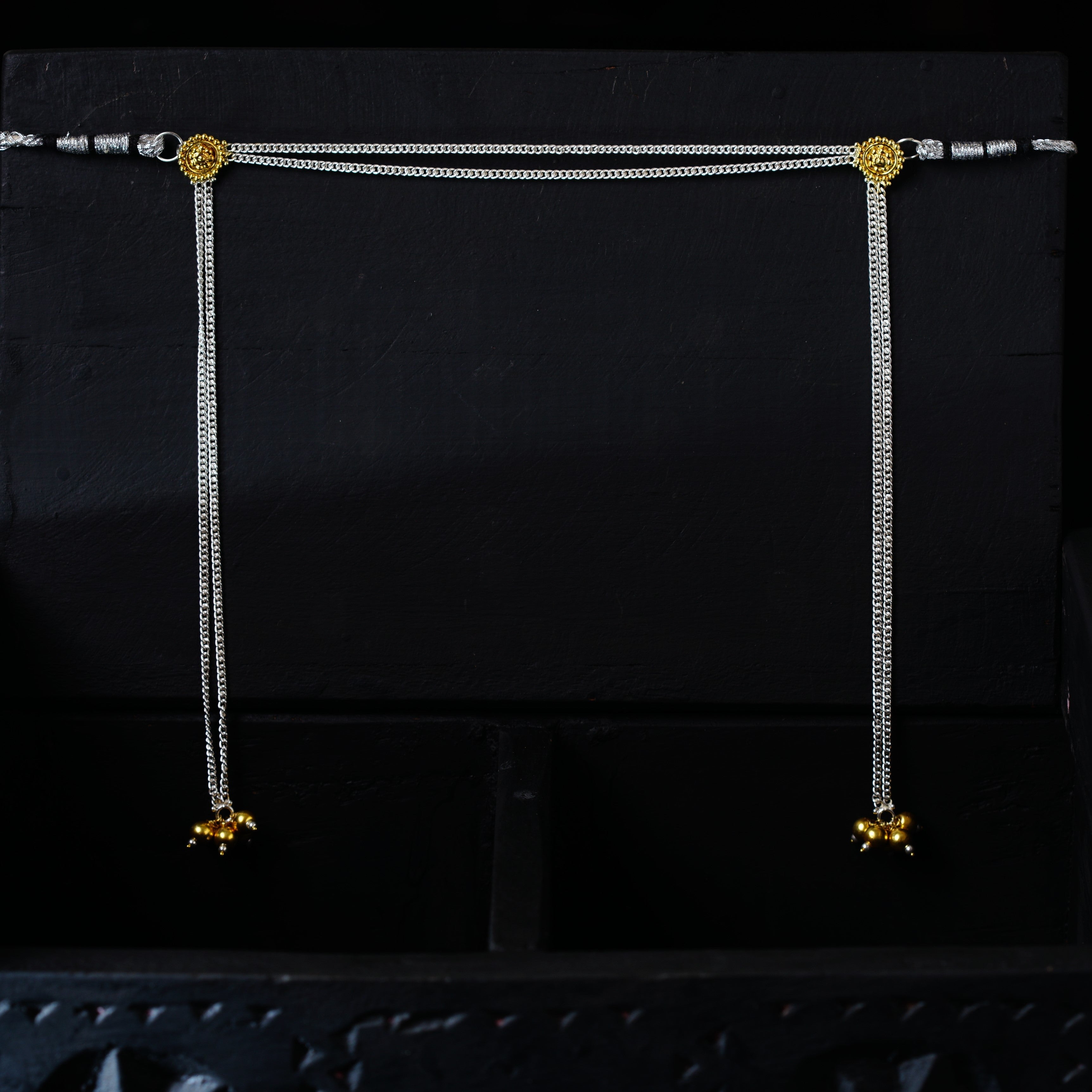 a pair of gold and silver earrings on a black background