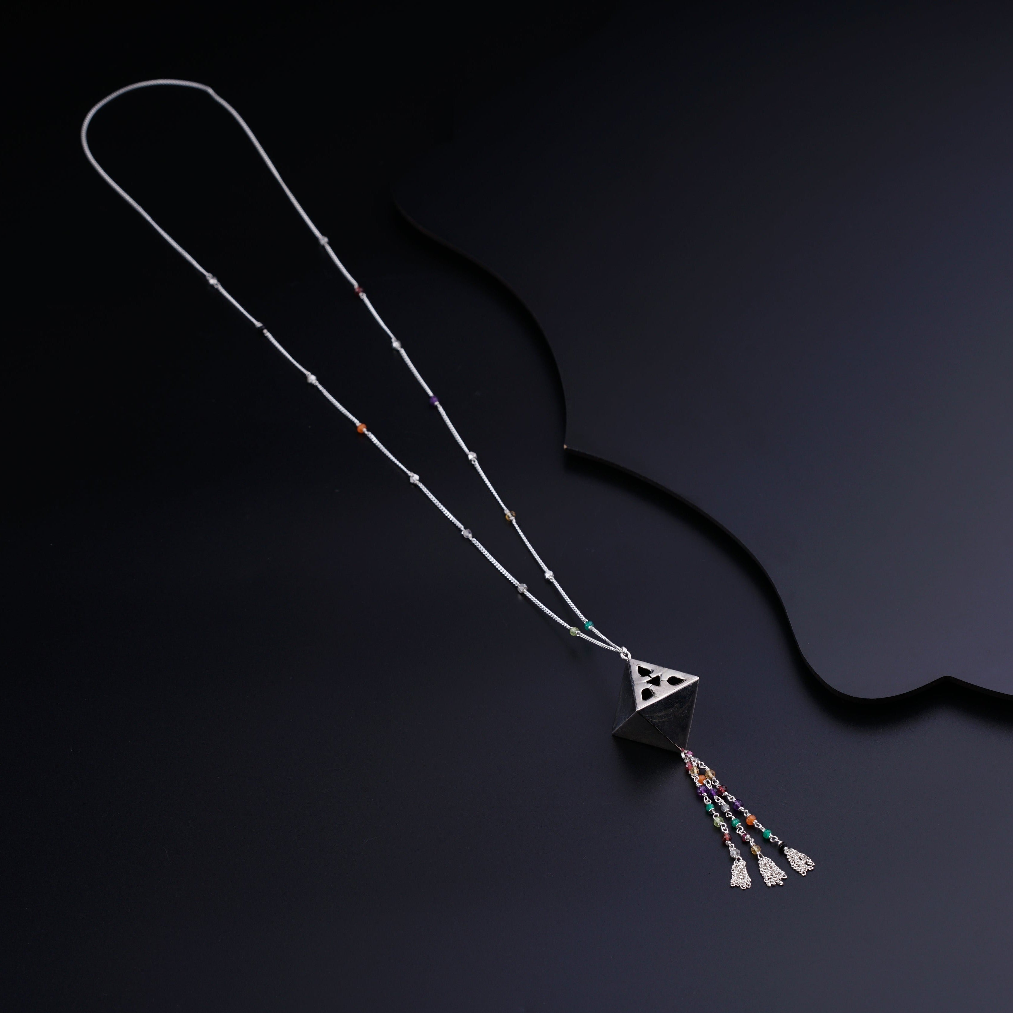 a long necklace with a triangle shaped pendant