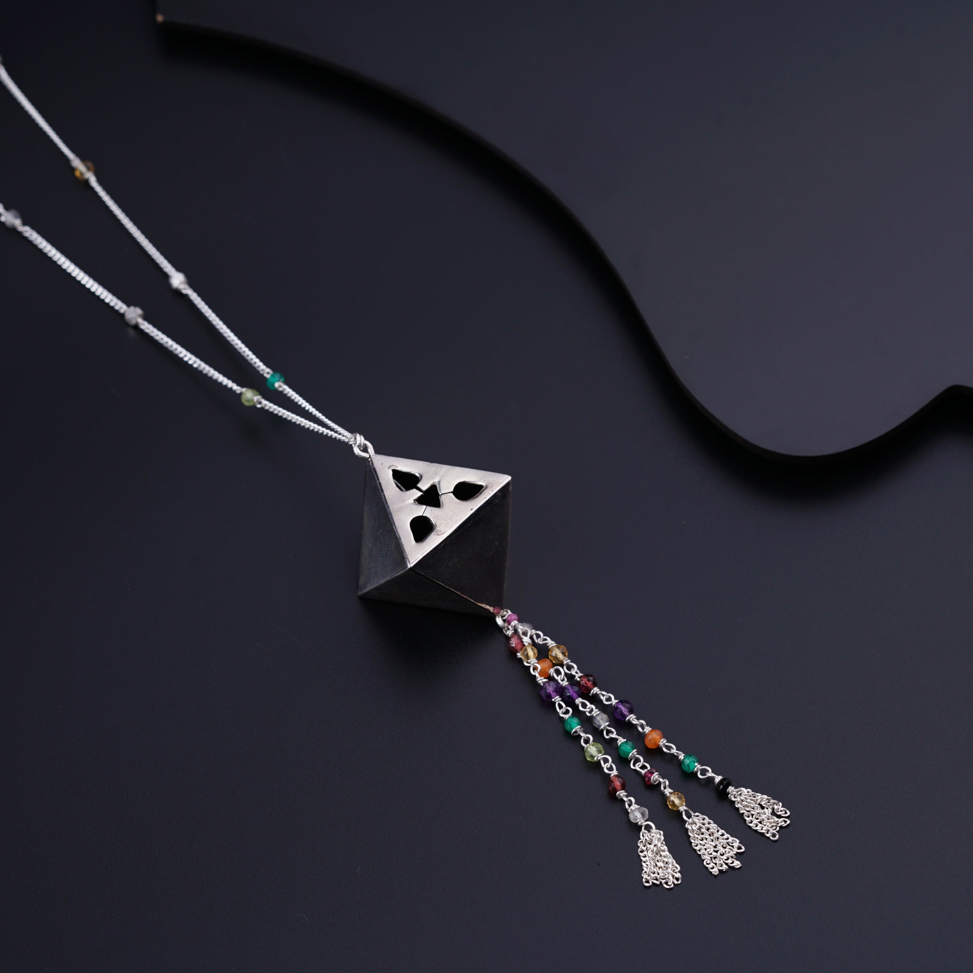 a necklace with a triangle and tassels hanging from it