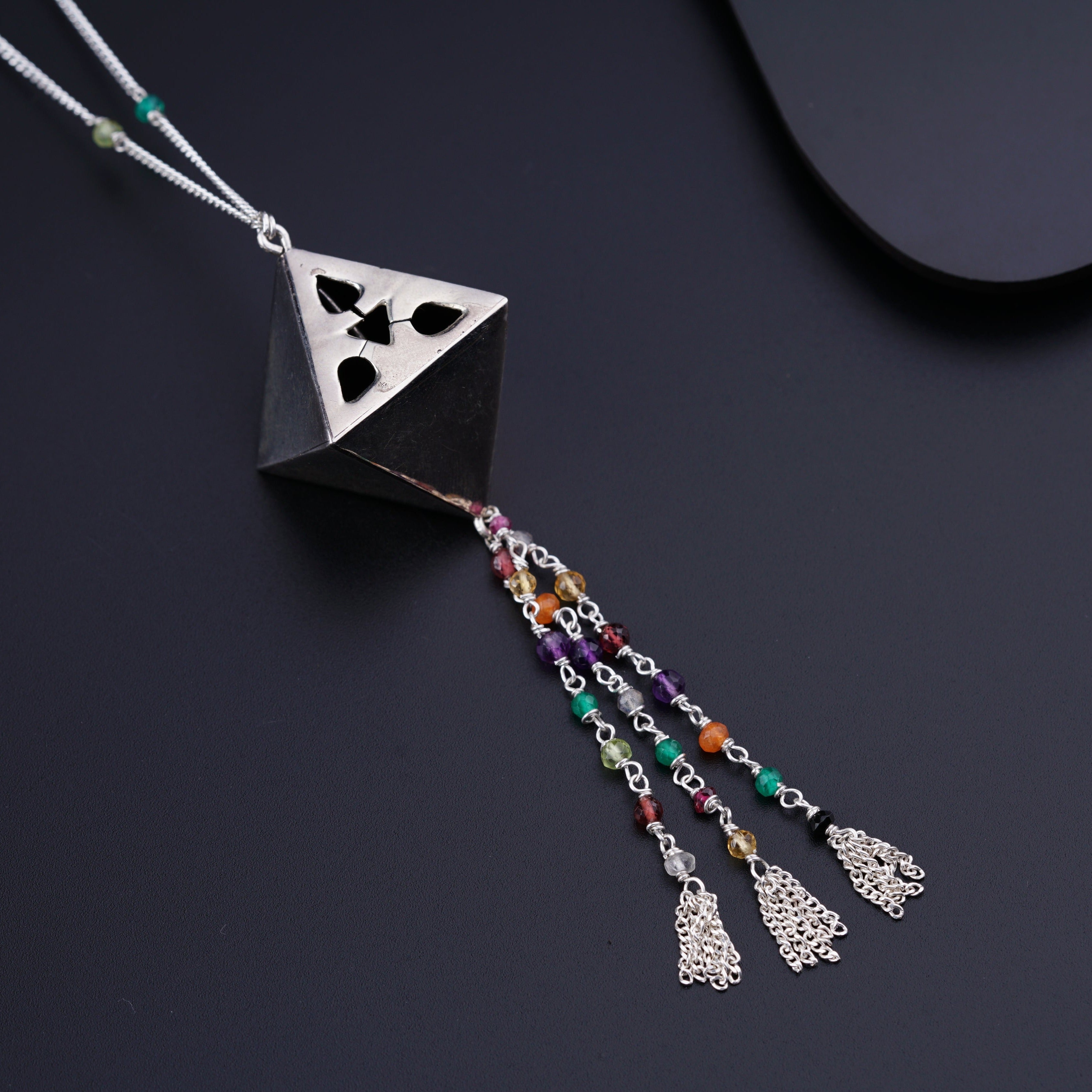 a necklace with a triangle shaped pendant and multicolored beads