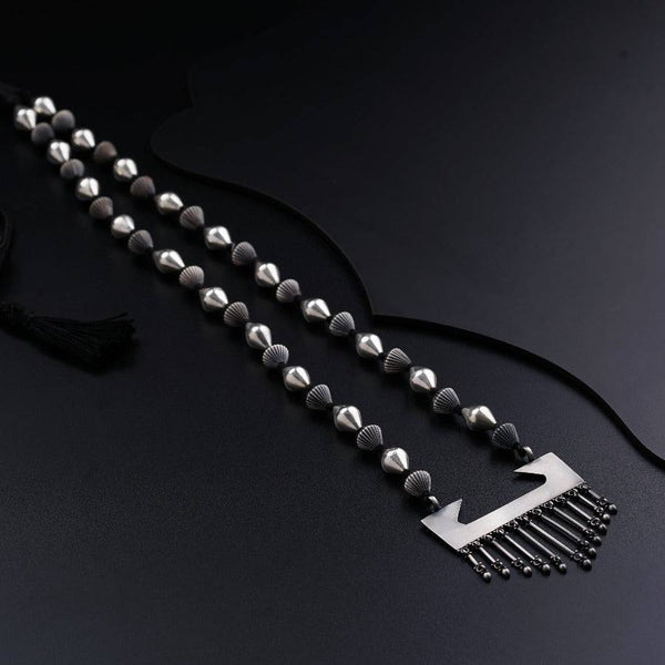 a black and white photo of a necklace