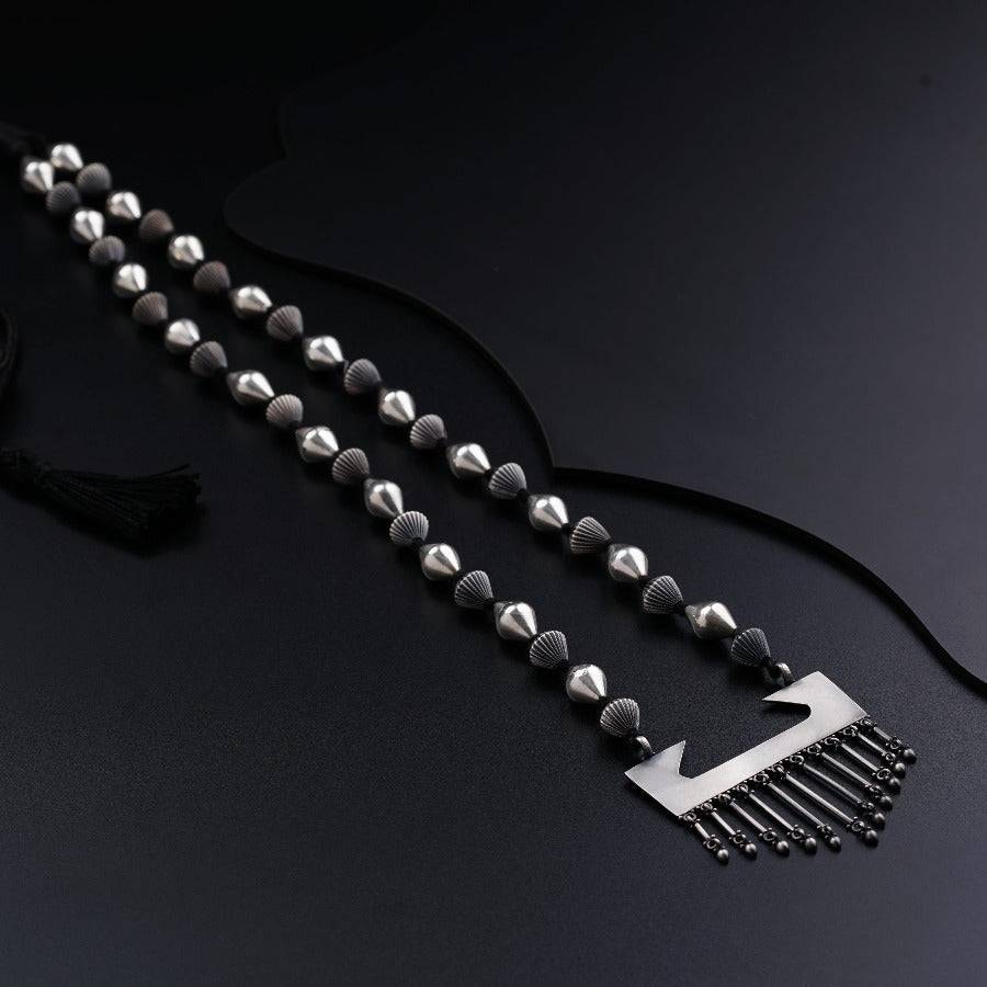 a black and white photo of a necklace