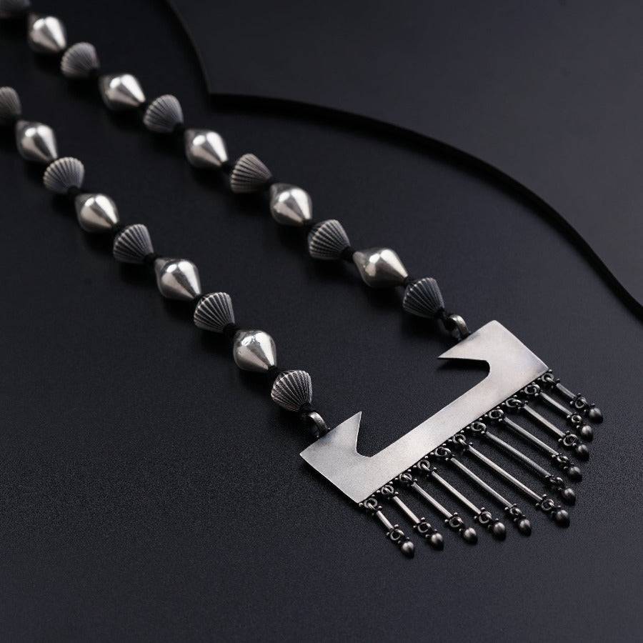 a metal comb with spikes on a black surface