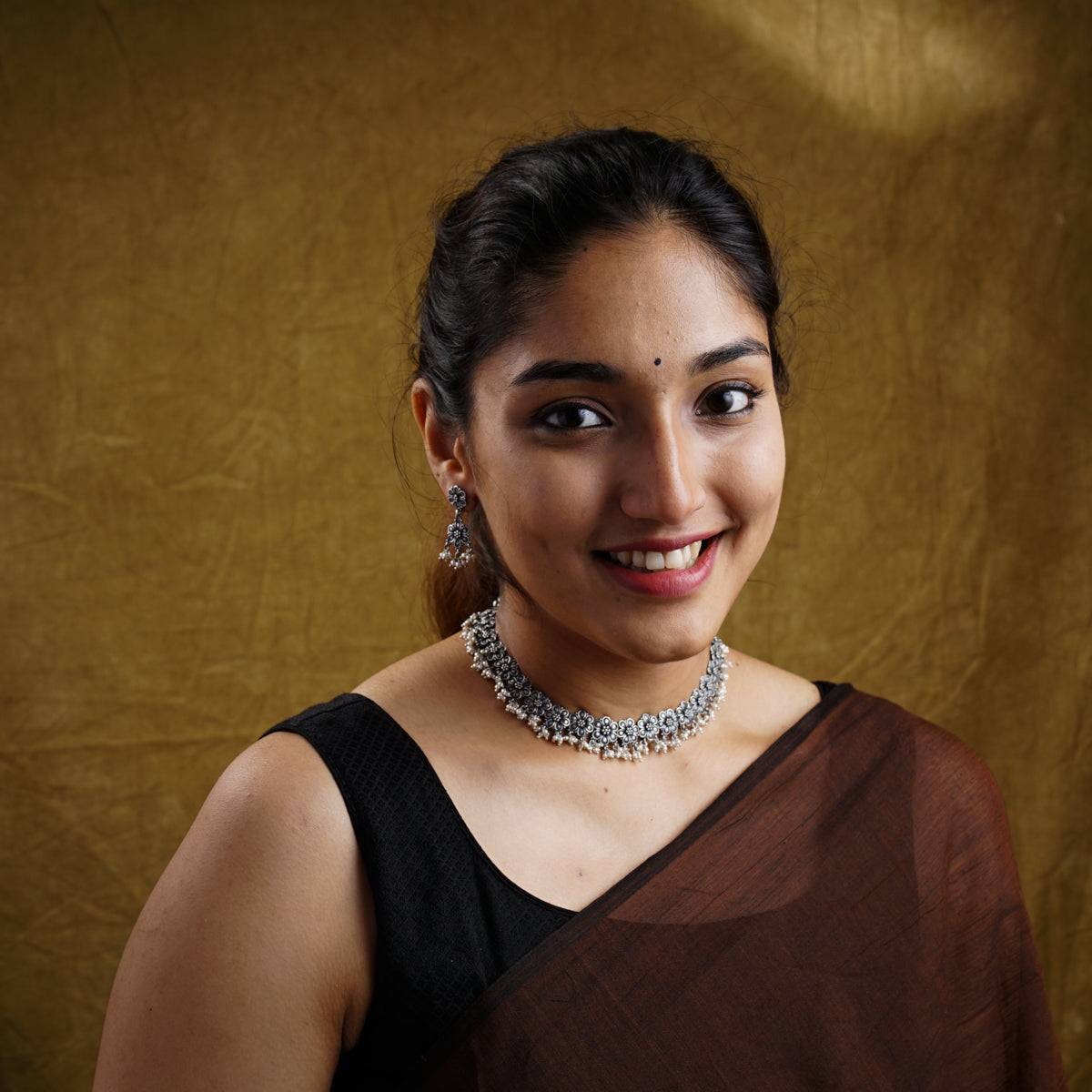 a woman wearing a necklace and a black dress