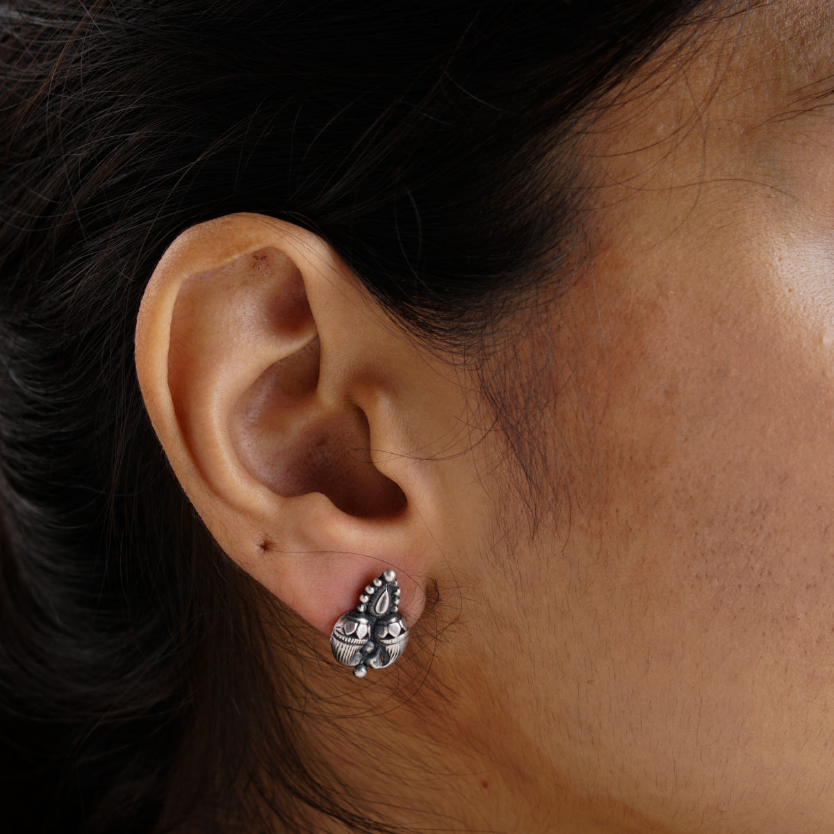 a close up of a person wearing a pair of earrings