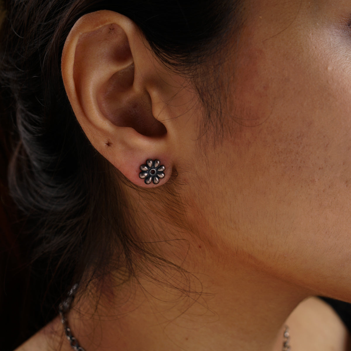 a close up of a person wearing a pair of earrings