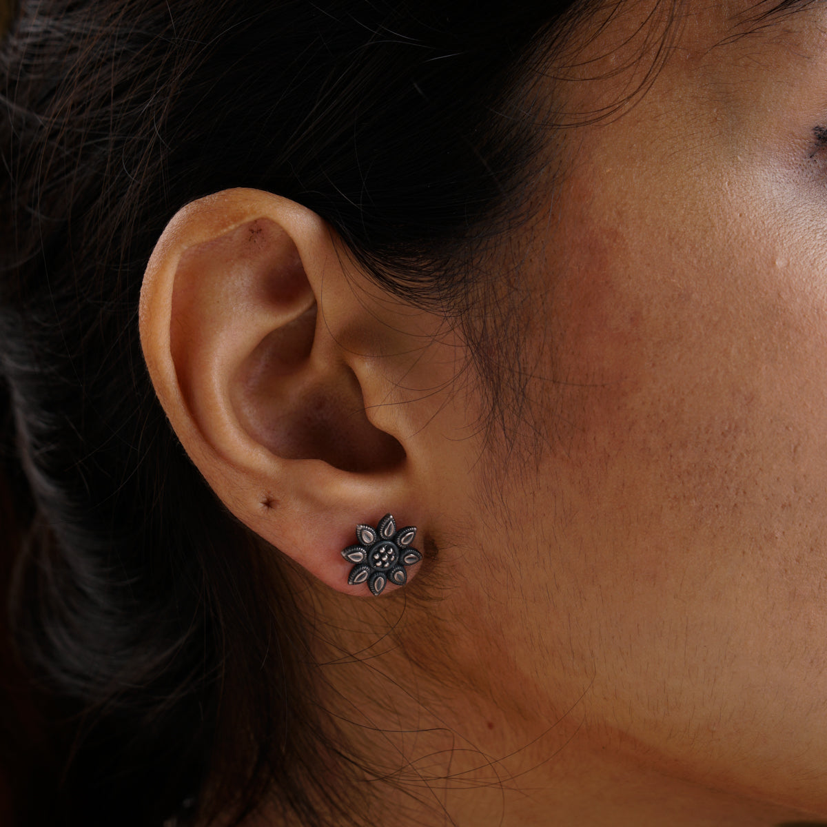 a close up of a person wearing a pair of earrings