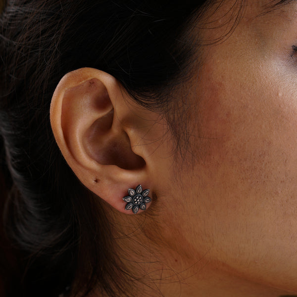 a close up of a person wearing a pair of earrings