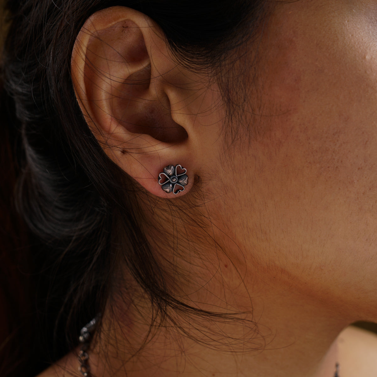 a close up of a person wearing a pair of earrings