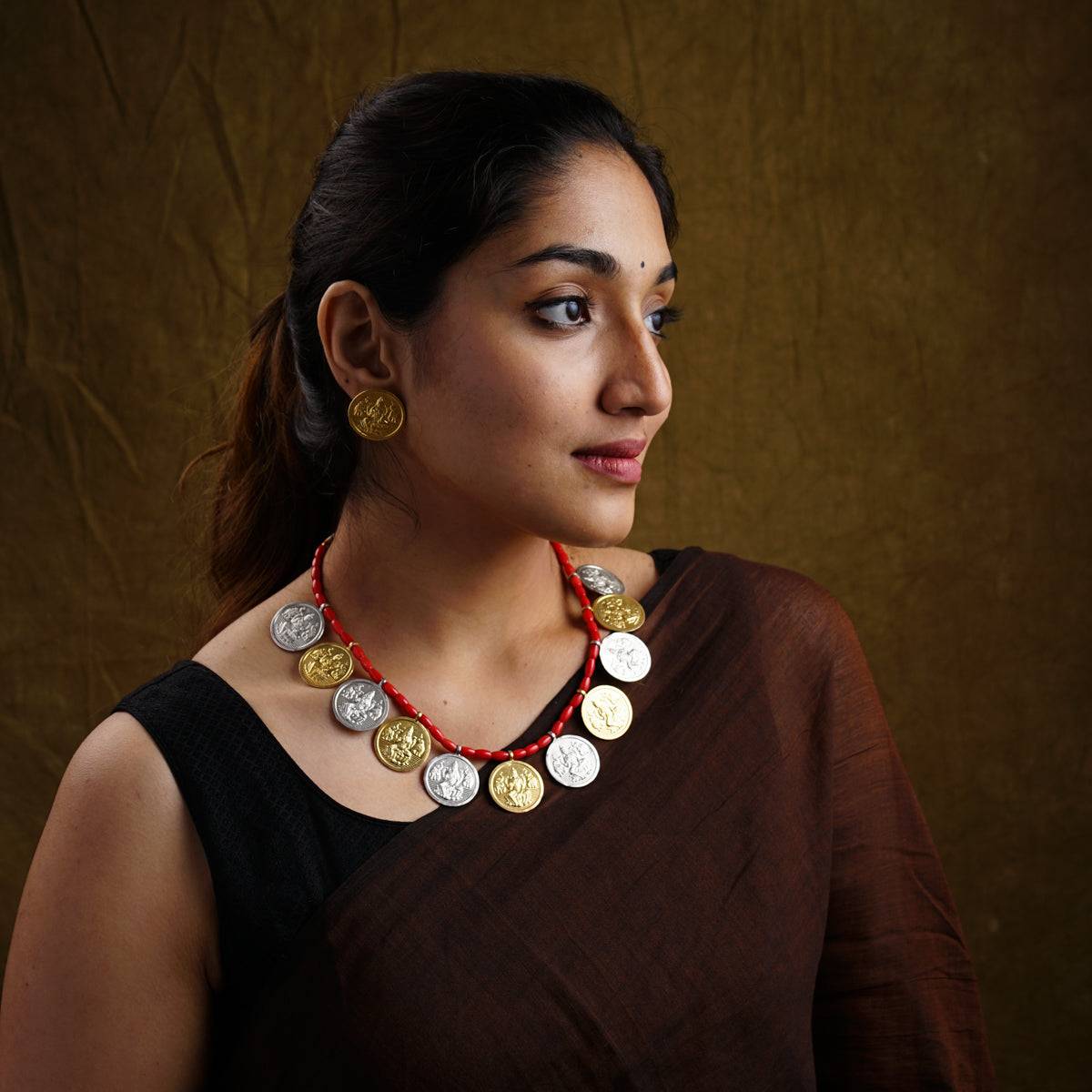 a woman wearing a necklace with coins on it