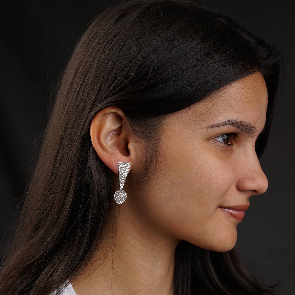 a close up of a person wearing a pair of earrings