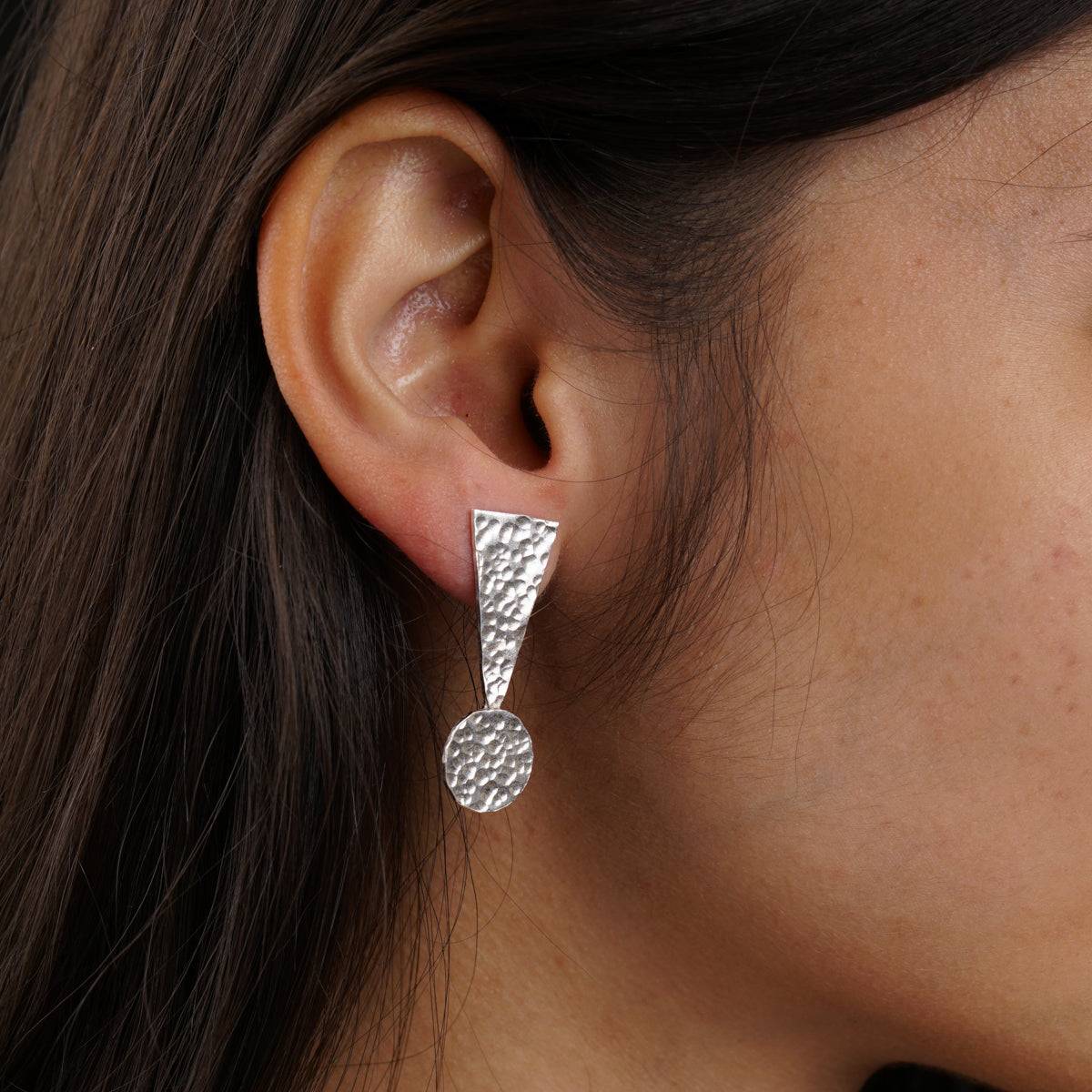 a close up of a person wearing a pair of earrings