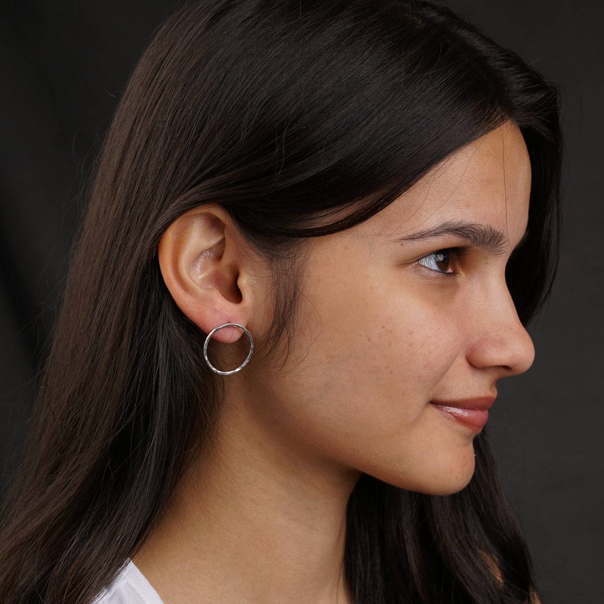 a close up of a person wearing a pair of earrings