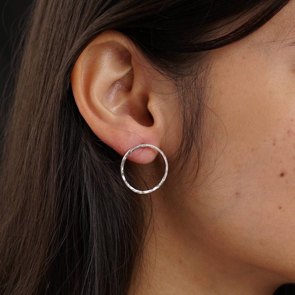 a close up of a person wearing a pair of earrings