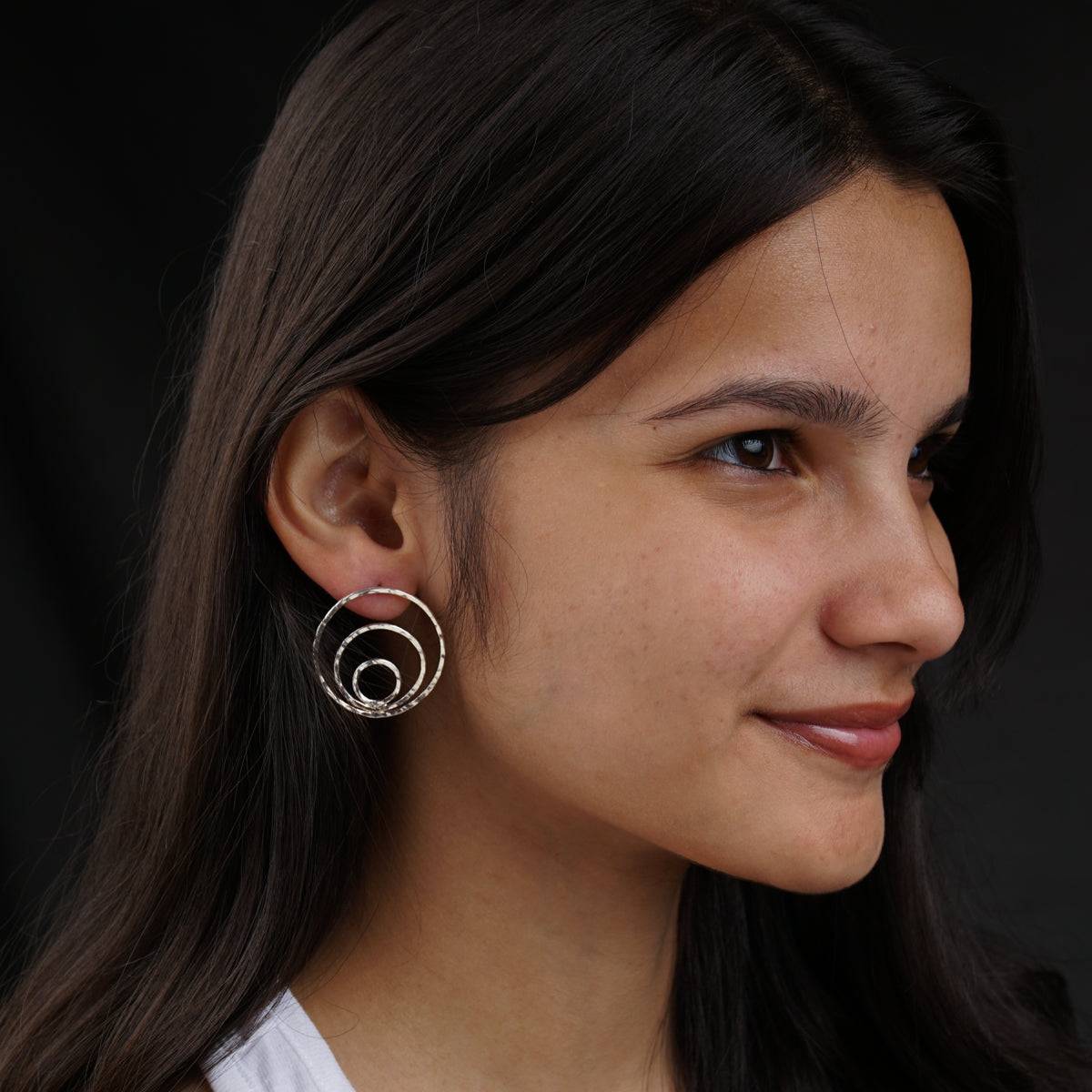 a close up of a person wearing a pair of earrings