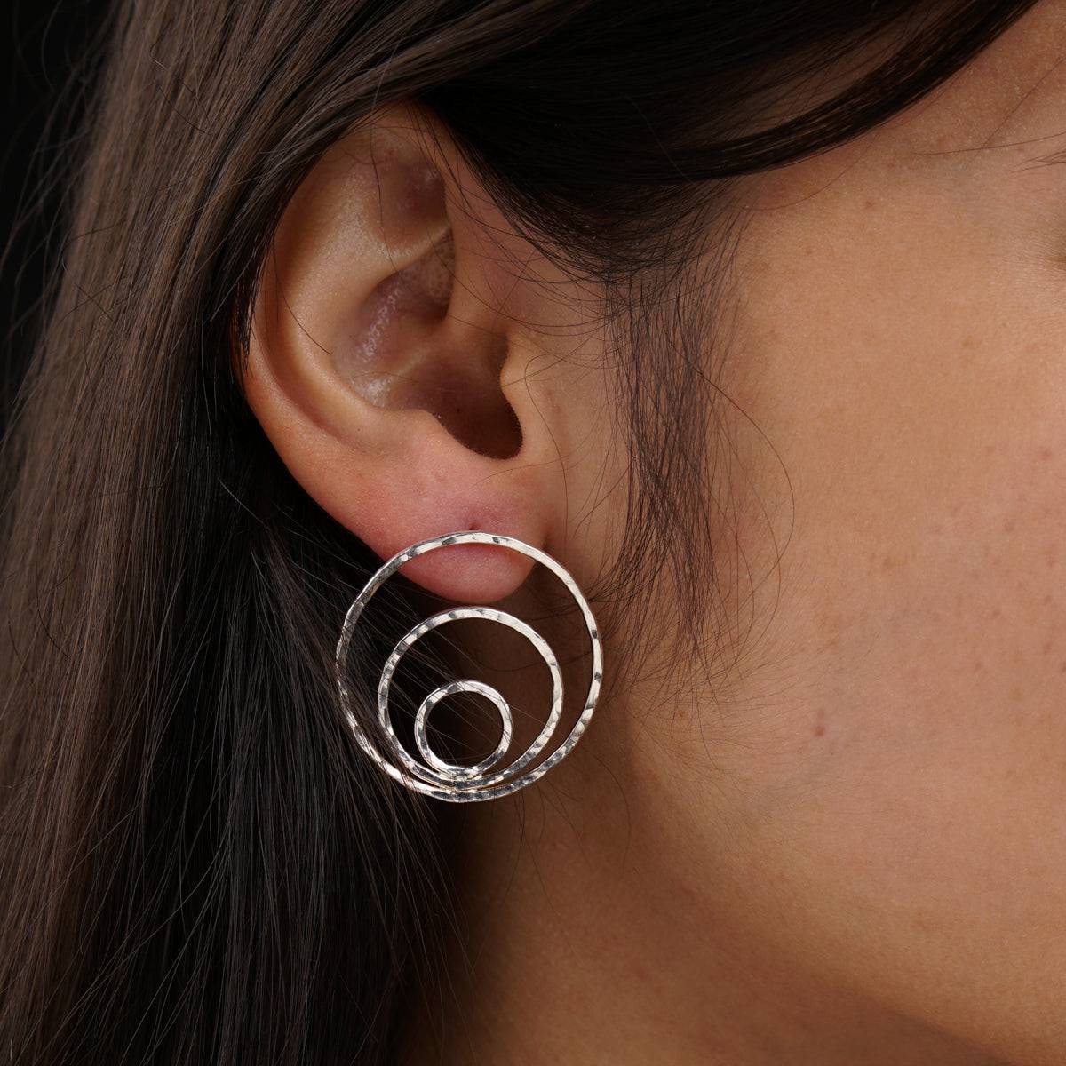 a close up of a person wearing a pair of earrings