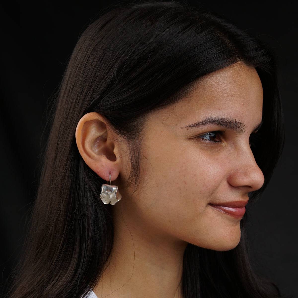 a close up of a person wearing a pair of earrings