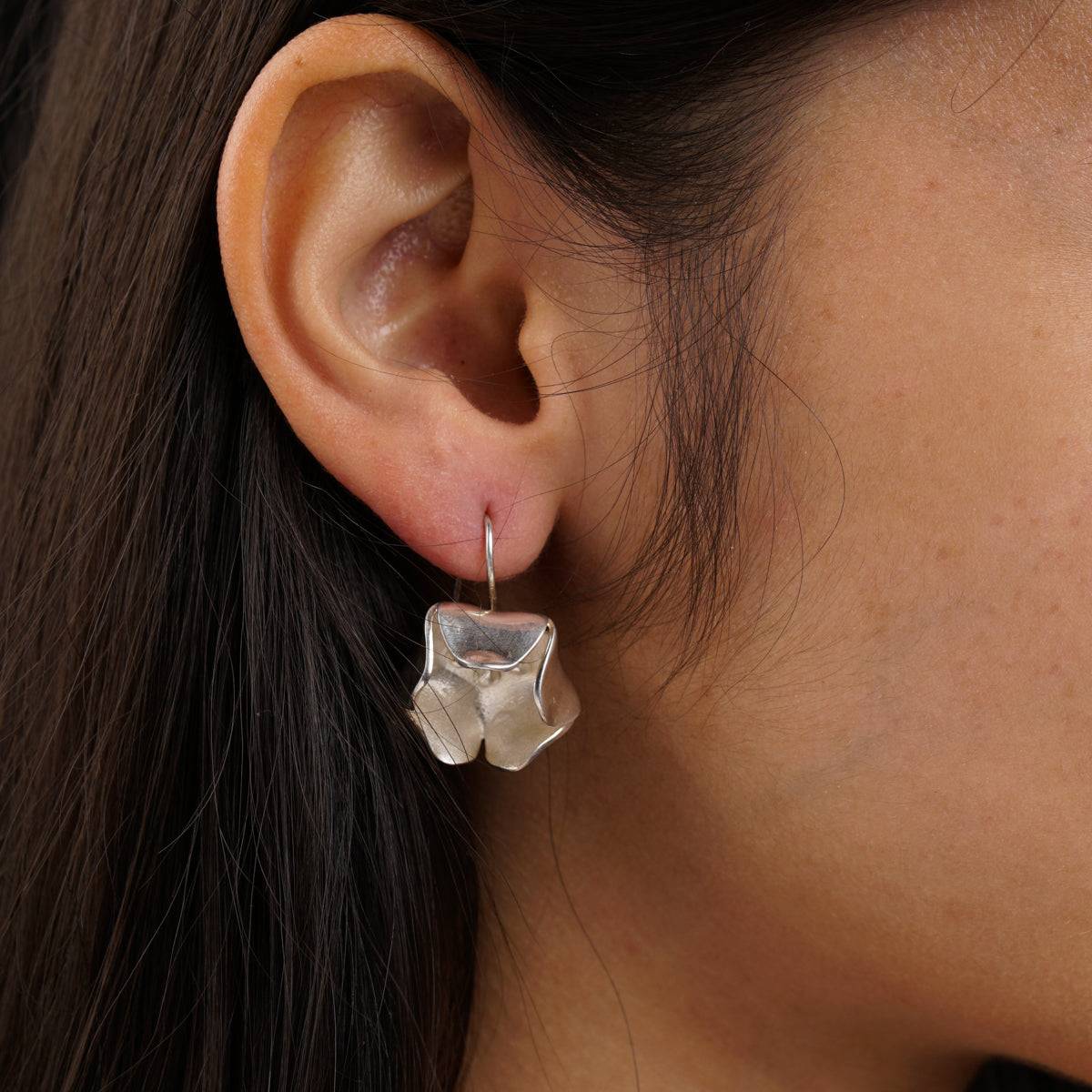 a close up of a person wearing a pair of earrings