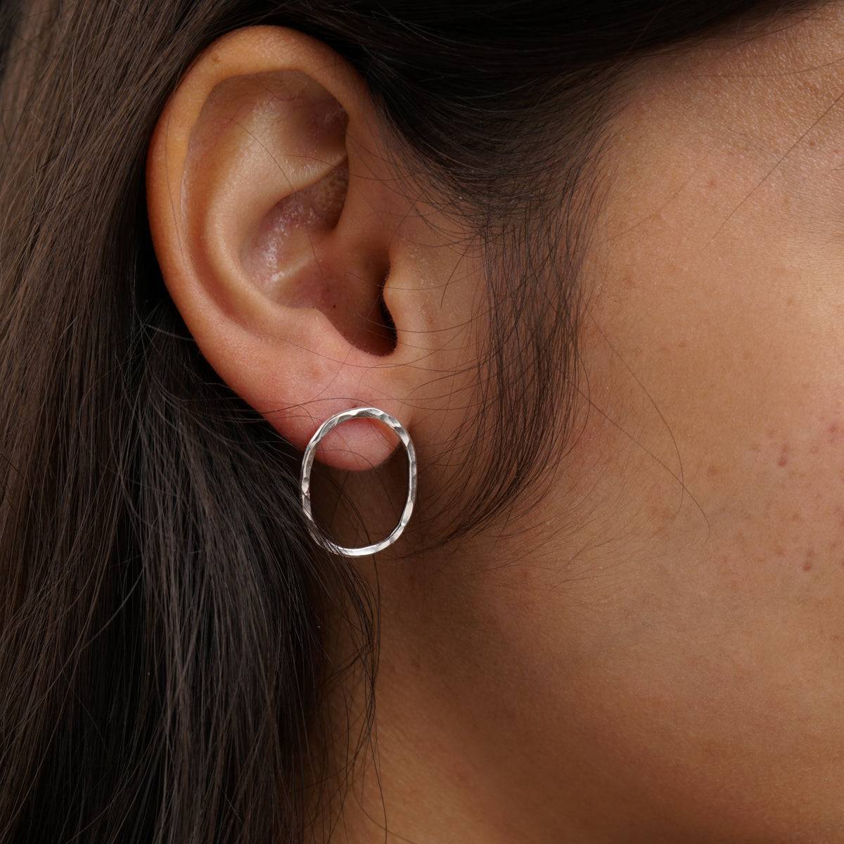 a close up of a person wearing a pair of earrings