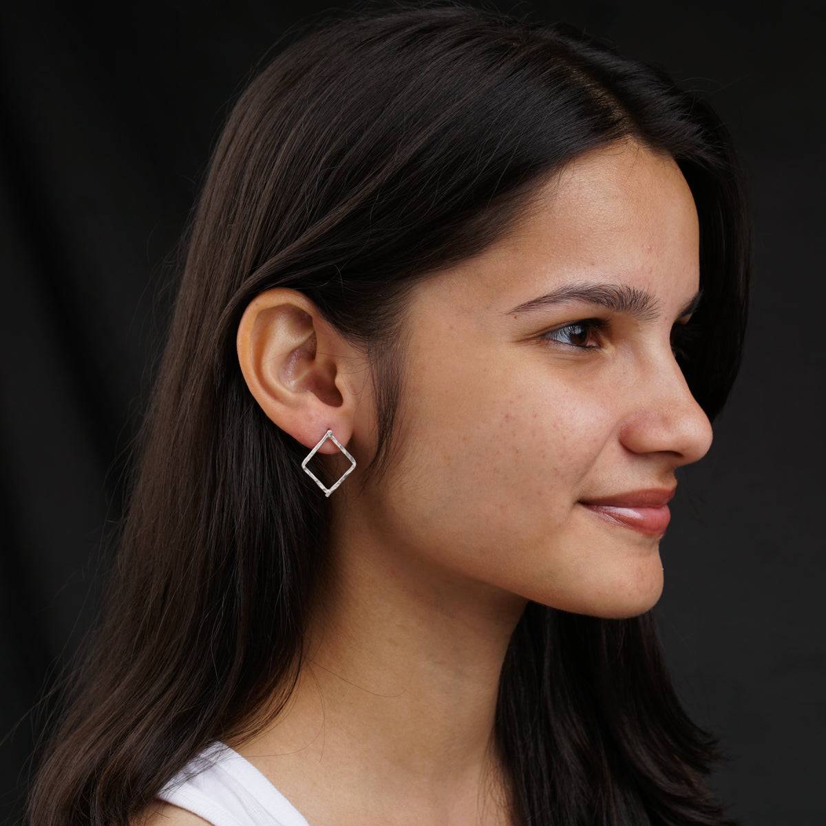 a close up of a person wearing a pair of earrings