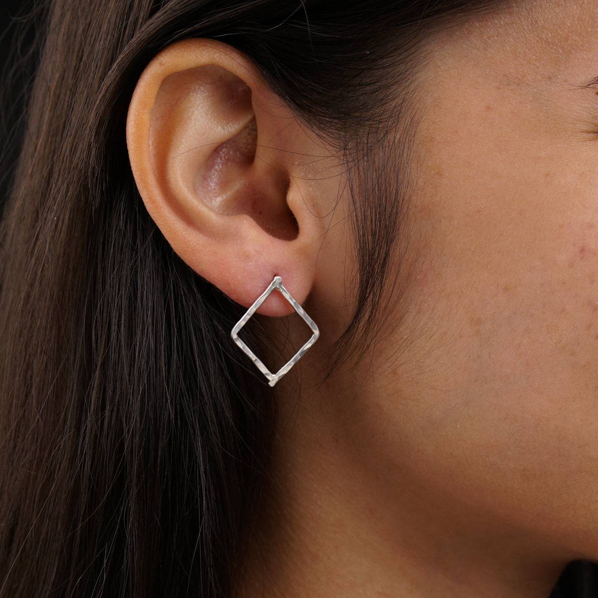 a close up of a person wearing a pair of earrings