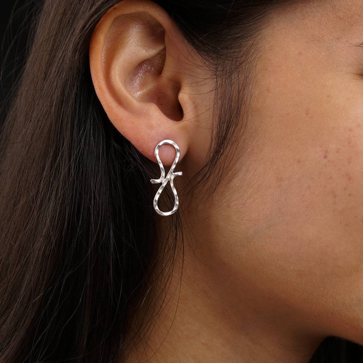 a close up of a person wearing a pair of earrings