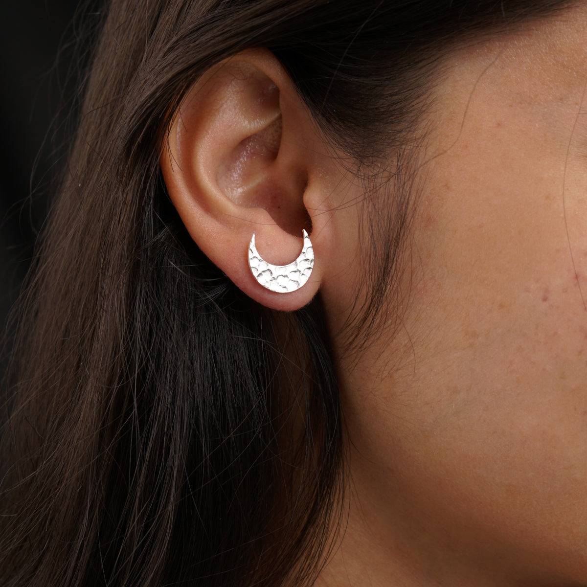 a close up of a person wearing a pair of earrings