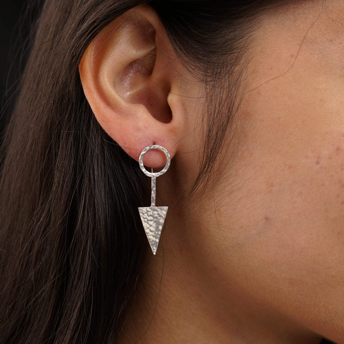 a close up of a person wearing a pair of earrings
