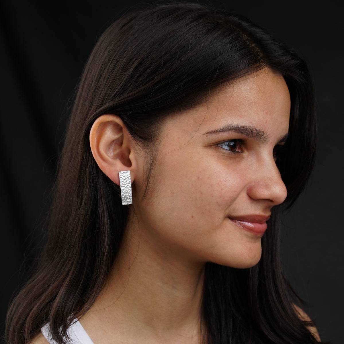 a close up of a person wearing a pair of earrings