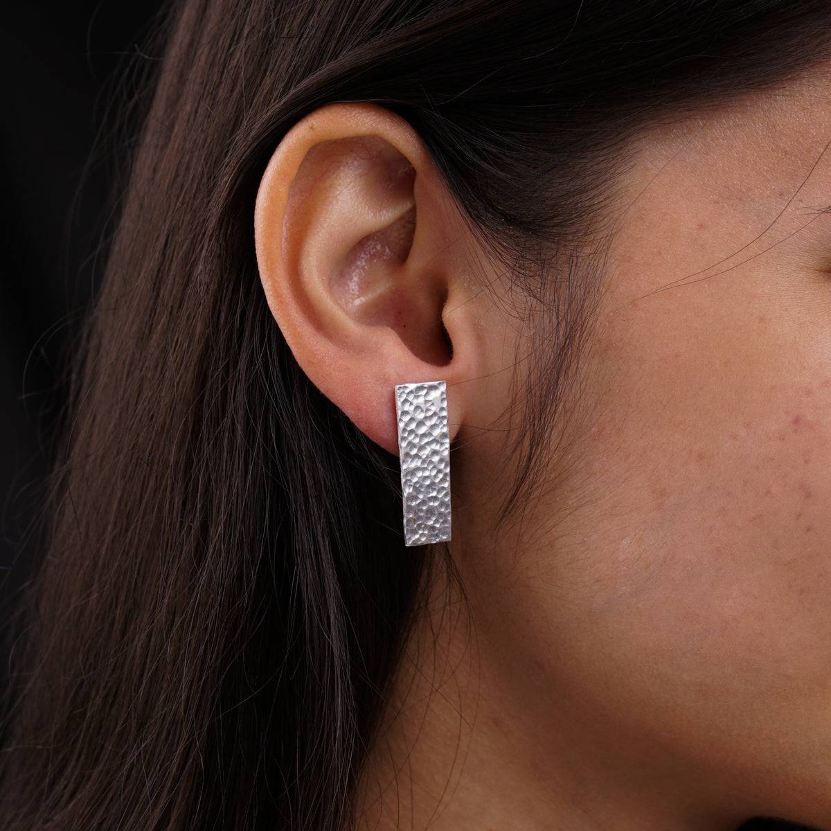 a close up of a person wearing a pair of earrings