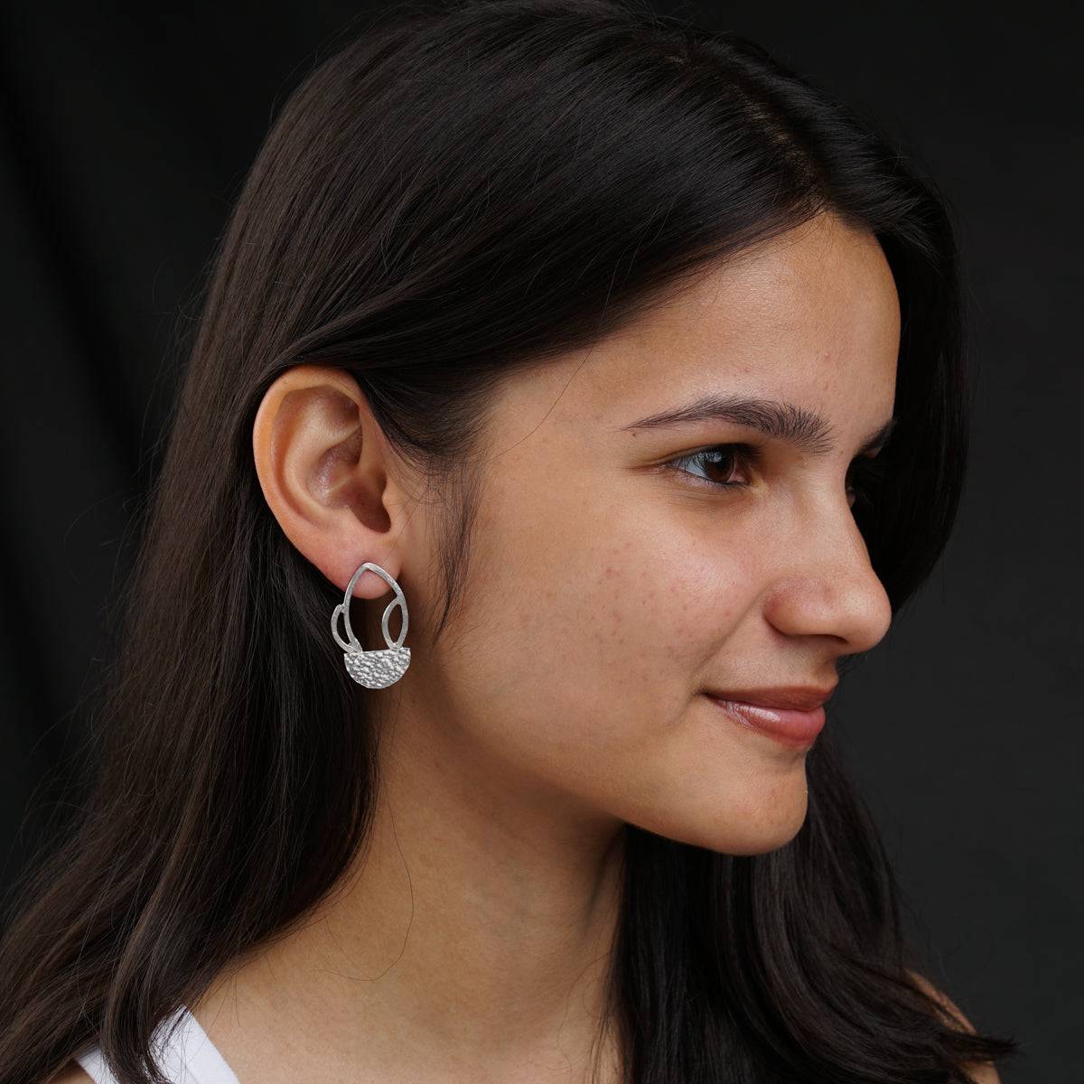 a close up of a person wearing a pair of earrings