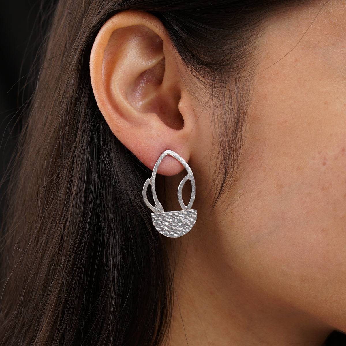 a close up of a person wearing a pair of earrings