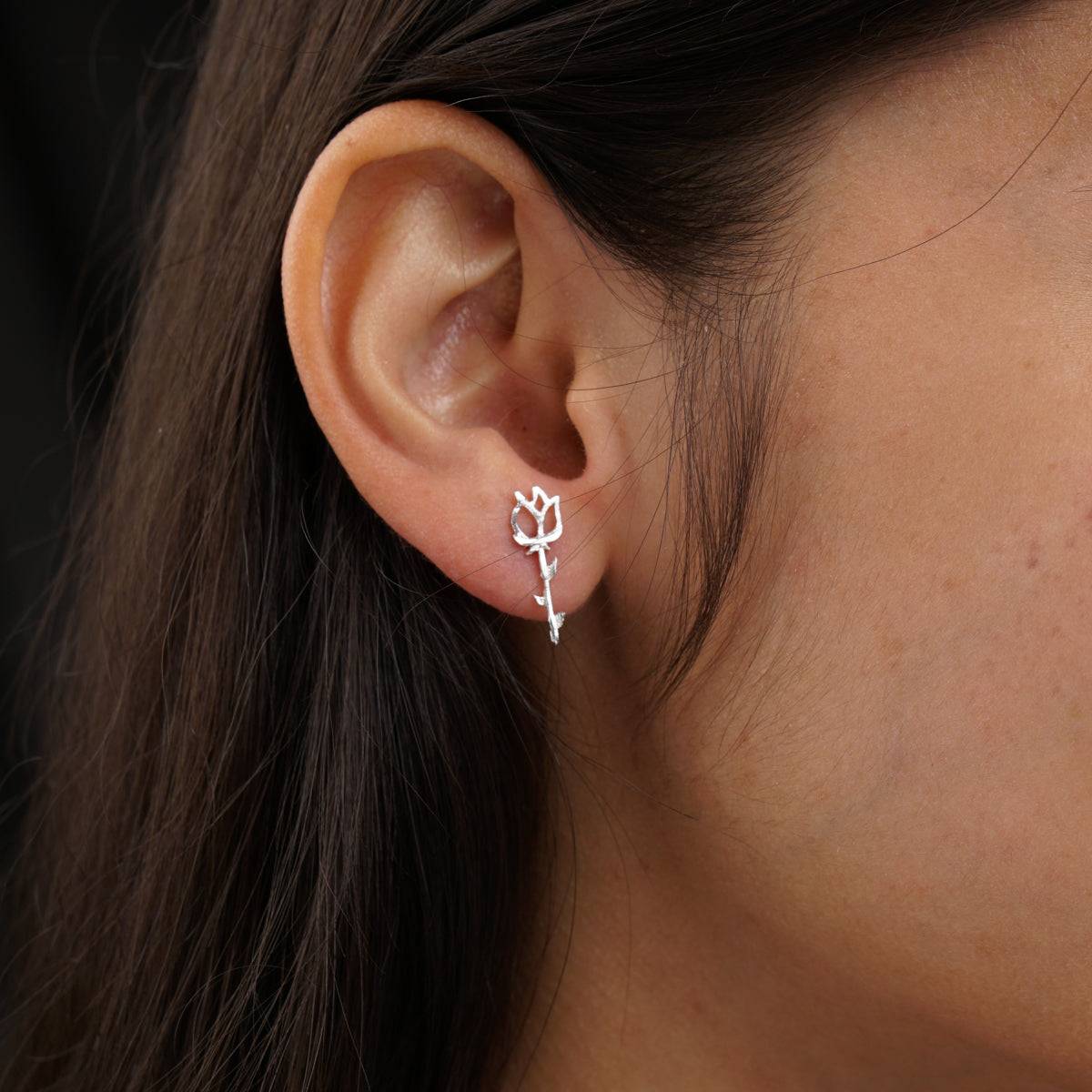 a close up of a person wearing a pair of earrings